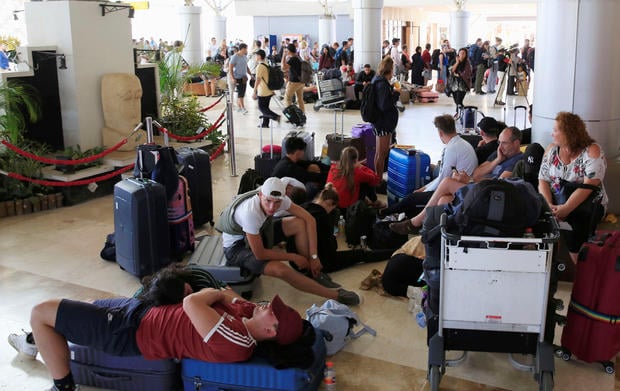 Foreign tourists sit and lie on the floor as they queue to leave Lombok Island after an earthquake hit