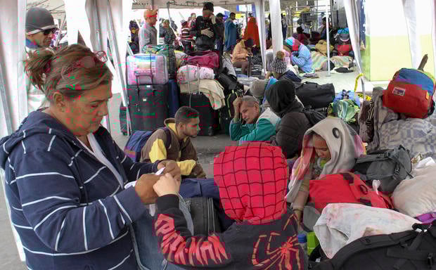 Venezuelan citizens wait in line to cross to Ecuador at the Rumichaca international bridge in Ipiales