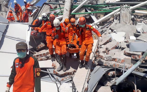 A search and rescue team evacuates a victim from the ruins of the Roa-Roa Hotel in Palu