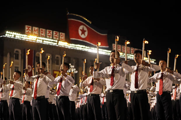 North Korean youths holding torches march during a torch light march at the Kim Il Sung Square in conjunction with the 70th anniversary of North Korea's founding day in Pyongyang