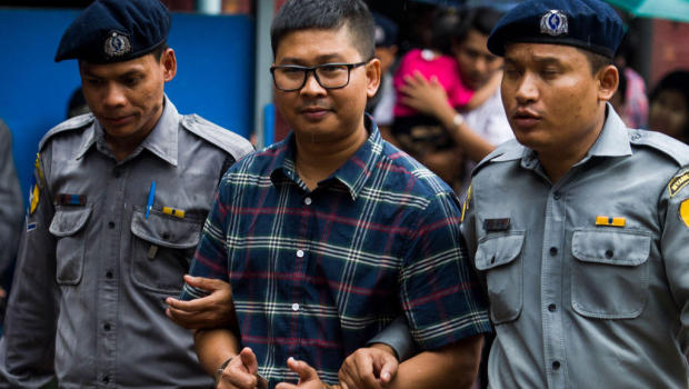 Detained Myanmar journalist Wa Lone (C) gives two thumbs up as he is escorted by police to a courtroom for his on going trial in Yangon on July 17