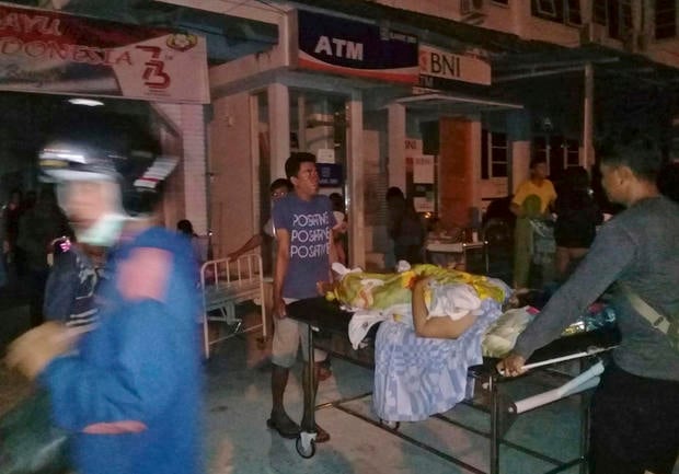 A patient is evacuated from a hospital following a strong earthquake in Poso