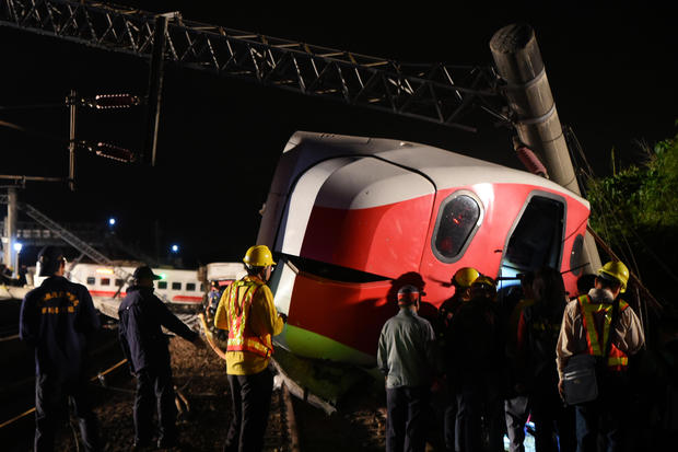 Rescuers search an overturned train in Yilan