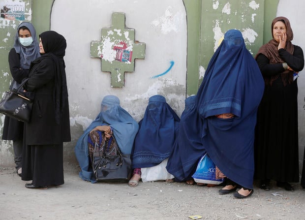 Afghan women line up to cast their votes during a parliamentary election at a polling station in Kabul