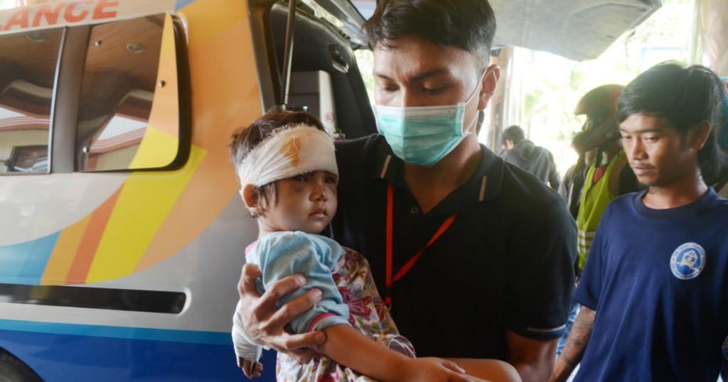 A man carries an injured child