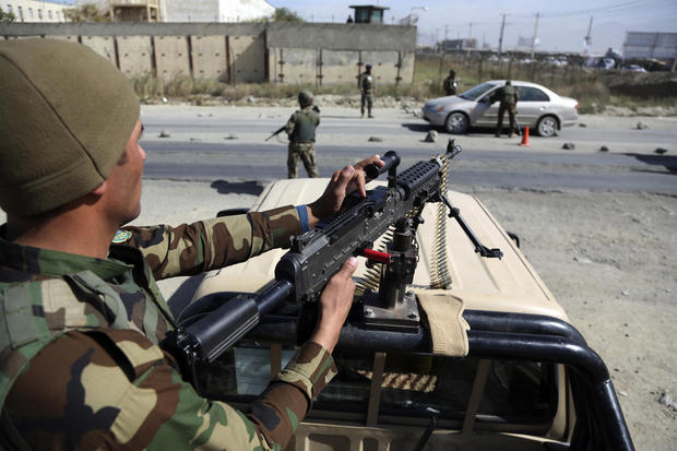 Afghan National army soldiers search a car at a checkpoint ahead of parliamentary elections scheduled for Oct. 20