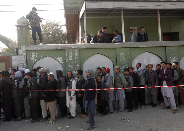 Afghan men line up to cast their votes during a parliamentary election at a polling station in Kabul 