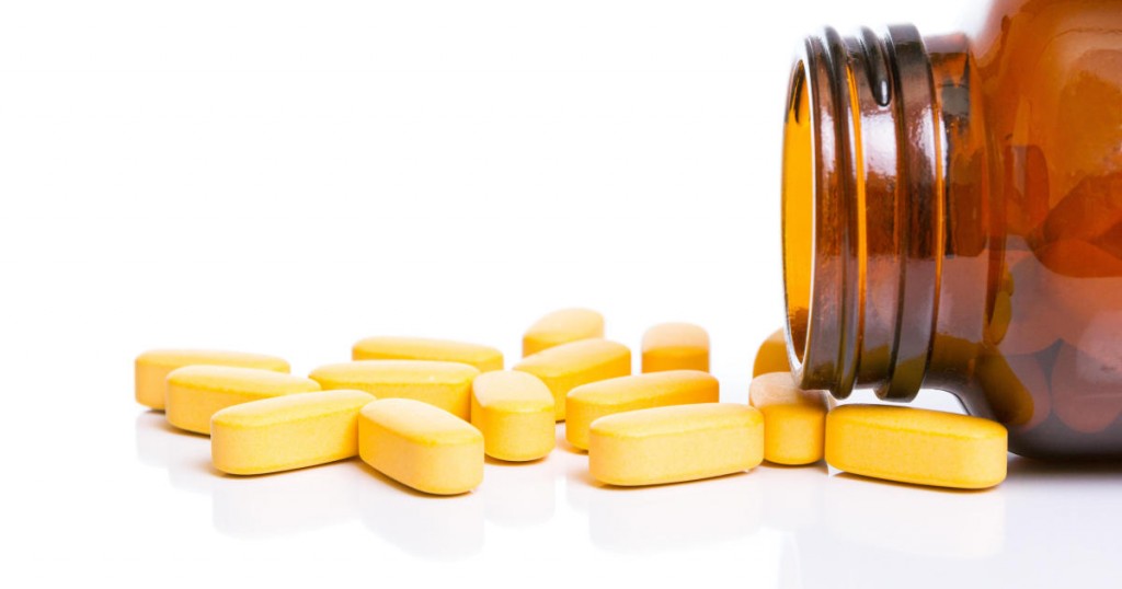 Vitamins and bottle on white background