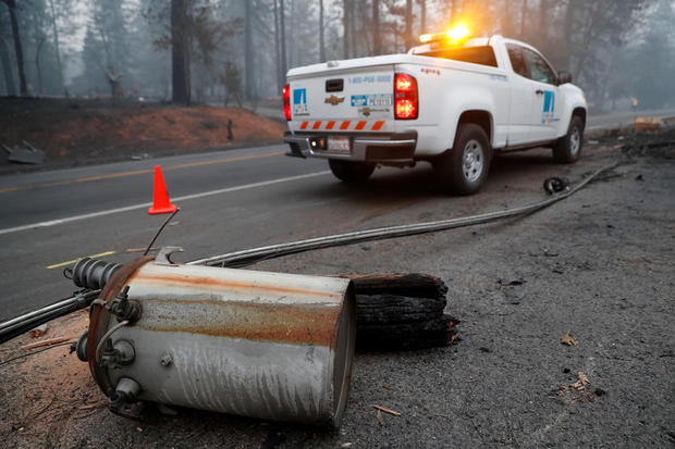 An electricity pole damaged by the Camp Fire lies near a Pacific Gas & Electric (PG&E) truck in Paradise