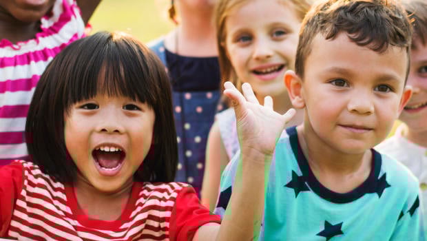 Group of kindergarten kids friends playing playground fun and smiling