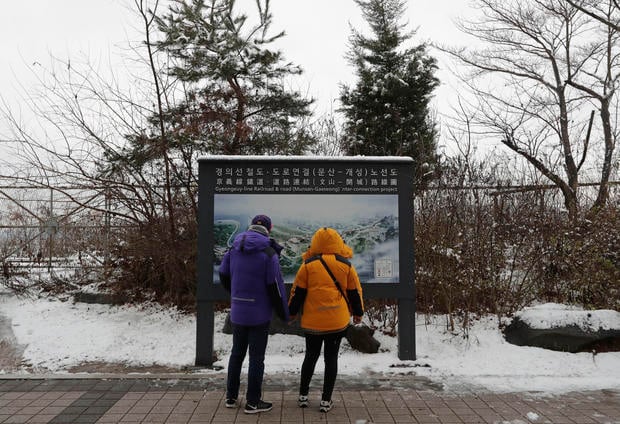Visitors look at a map of railroad and road between two Koreas cities