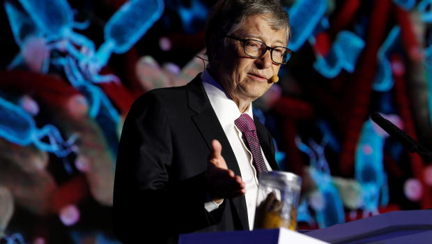 Microsoft founder Bill Gates points at a jar containing human faeces during his speech at the Reinvented Toilet Expo showcasing sewerless sanitation technology in Beijing