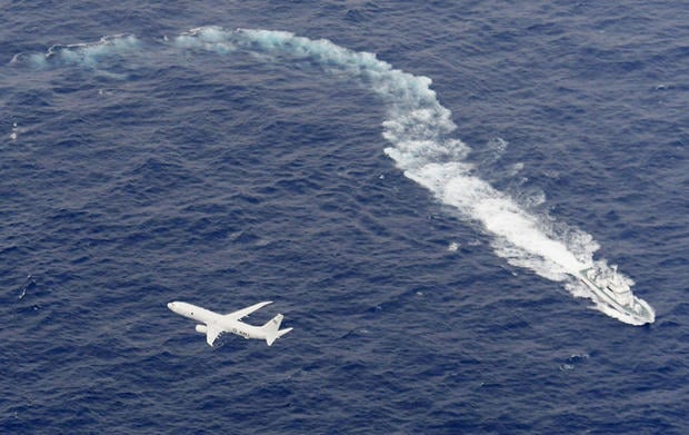 A Japan Coast Guard patrol vessel and U.S. Navy airplane conduct search and rescue operation at the area where two U.S. Marine Corps aircraft have been involved in a mishap in the skies