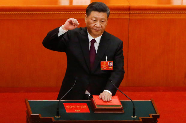 Chinese President Xi Jinping pledges an oath to the Constitution after being confirmed president for another term during the fifth plenary session of the National People's Congress (NPC) at the Great Hall of the People in Beijing