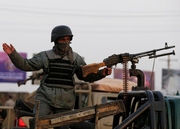 An Afghan policeman keeps watch at a back of truck at the site of an attack in Kabul 
