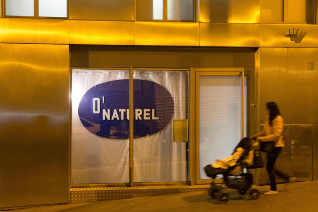 A woman pushes a stroller past the nudist restaurant O'Naturel" in Paris on Dec. 5, 2017. 