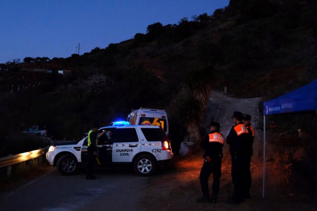 Emergency team members look for a boy fell into the 100-meter-deep waterhole in a mountainous area near the town of Totalan in Malaga