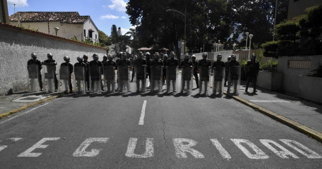 Members of the Bolivarian National Guard stand guard near the main entrance of the forces' headquarters in Caracas as supporters of Venezuela's National Assembly head and self-proclaimed "acting president" Juan Guaido