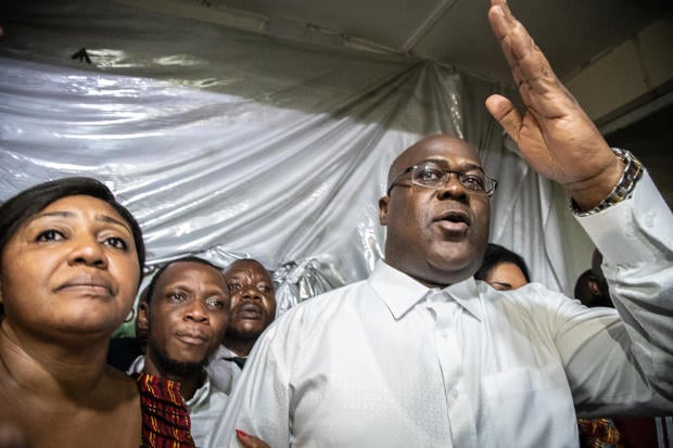 Felix Tshisekedi gestures as he is surrounded by his wife