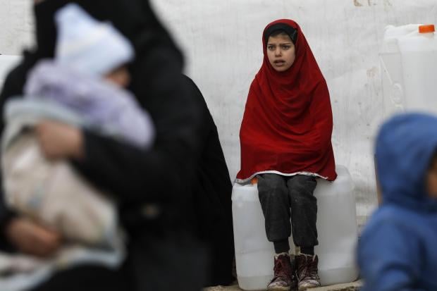 A Syrian girls looks on as aid items to cope with the winter weather are delivered to the al-Hol refugee camp in al-Hasakeh governorate in northeastern Syria on January 07