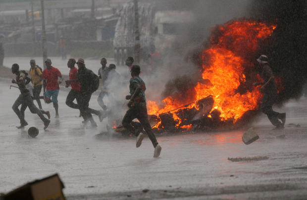 FILE PHOTO: People run at protest as barricades burn during rainfall in Harare 