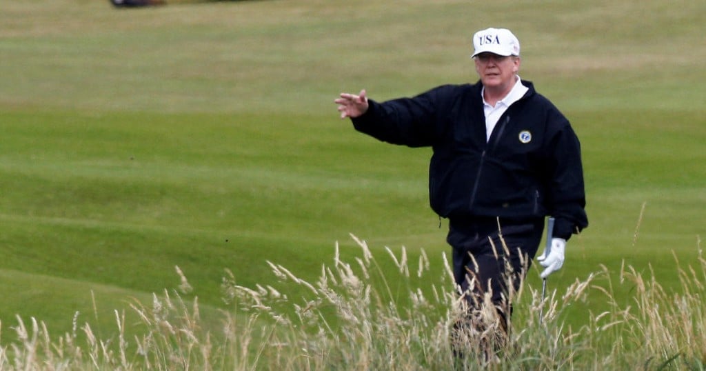 U.S. President Donald Trump gestures as he walks on the course of his golf resort