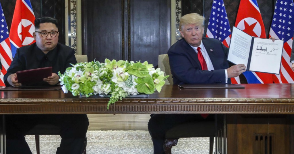 U.S. President Donald Trump holds up the document that he and North Korea leader Kim Jong Un just signed at the Capella resort on Sentosa Island Tuesday