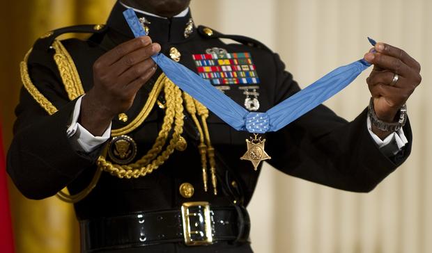 A military aide holds up the Medal of Honor as the citation is read before US President Barack Obama awarded US Marine Corps SGT Dakota Meyer in the East Room of the White House in Washington