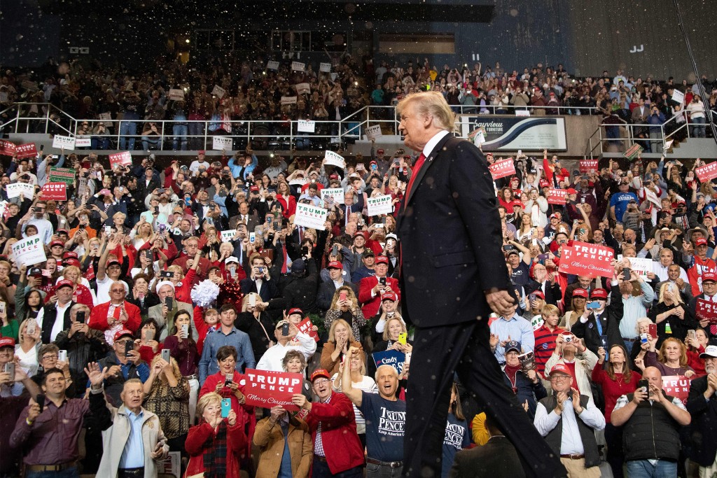 US President Donald Trump walks on stage under fake snow fall at a Make America Great Again rally in Biloxi