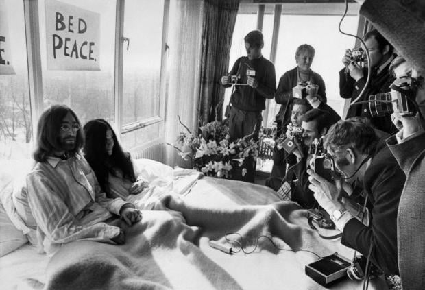 Beatles member John Lennon and his wife Yoko Ono receive journalists in their bedroom at the Hilton hotel in Amsterdam during their honeymoon in Europe March 25, 1969. 
