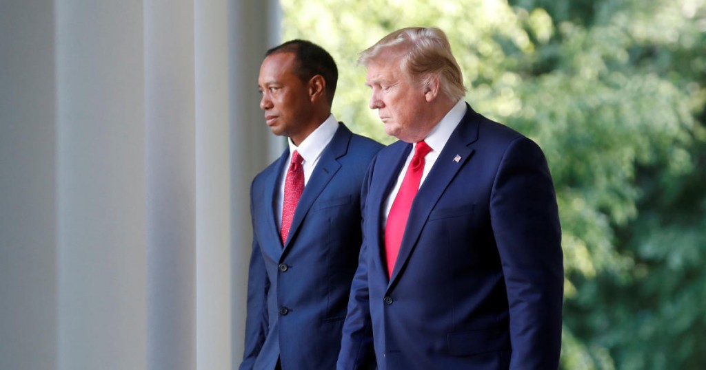 U.S. President Donald Trump walks with Tiger Woods before presenting him with the Presidential Medal of Freedom