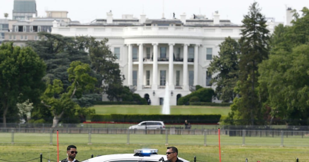 Law enforcement personnel stand near the Ellipse south of the White House on Constitution Avenue
