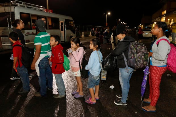 Migrants hoping to reach the U.S. wait in line to board a bus toward Honduras' border with Guatemala as hundreds of migrants set off by bus or on foot from a main bus station in San Pedro Sula