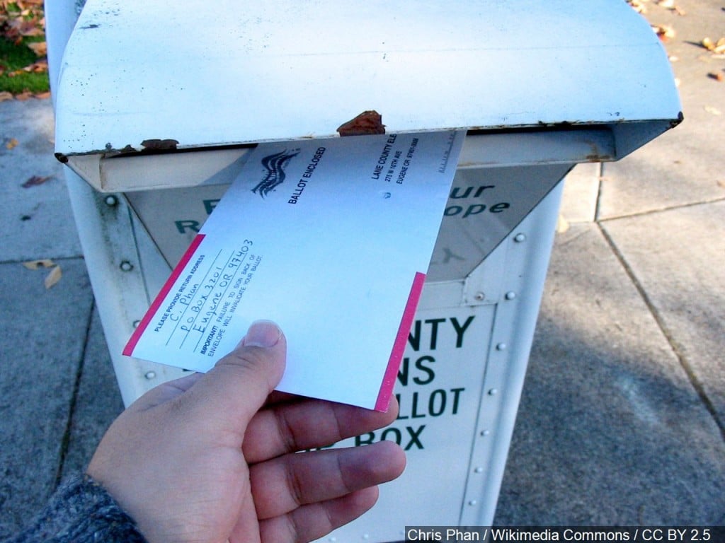 A vote-by-mail ballot is returned to a ballot drop box