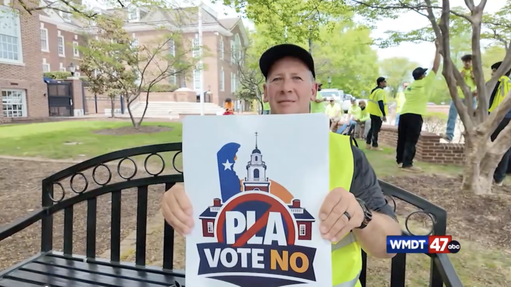 Man holds a sign that reads "PLA vote no"
