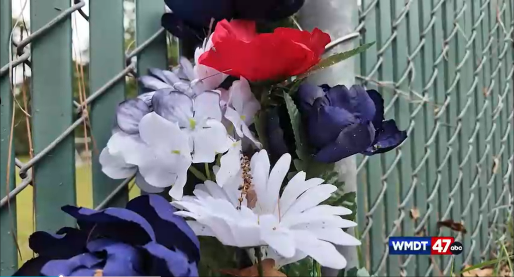 Bouquet of plastic flowers serve as a memorial where Rinier was killed.