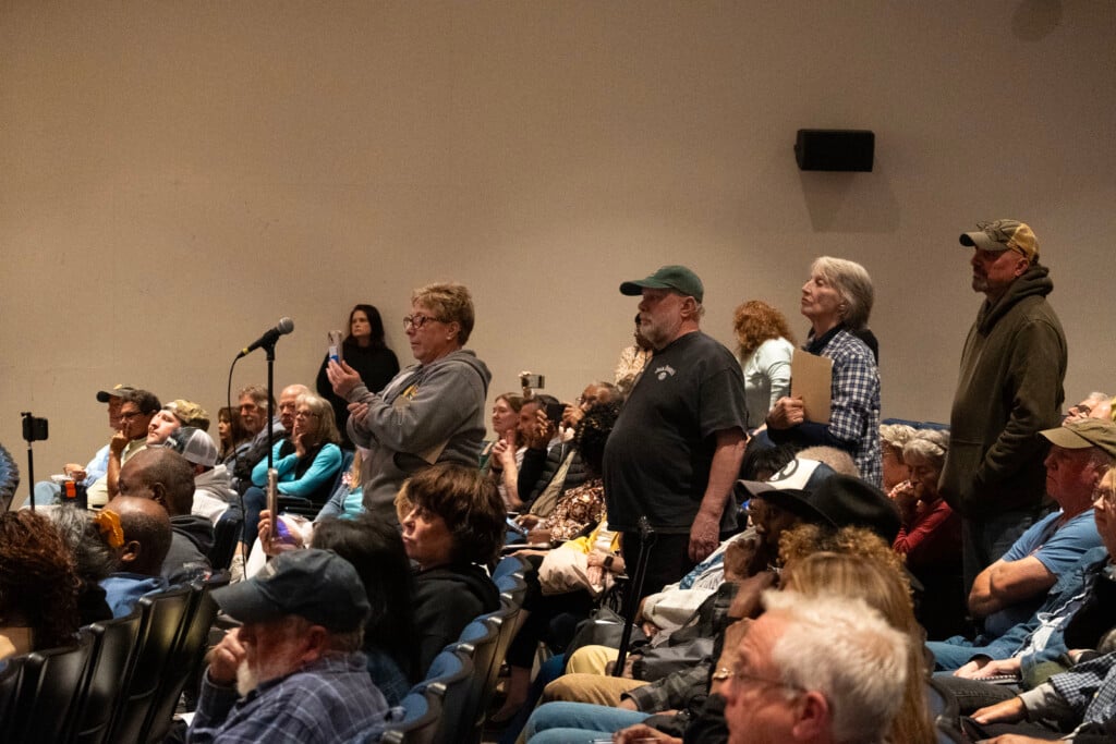 Residents line up to a mic stand to ask questions.