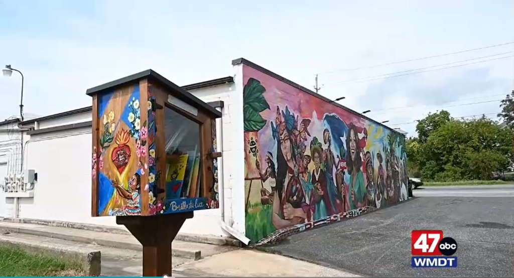 Shine Your Light Little Free Library to the left of the Shine Your Light Mural