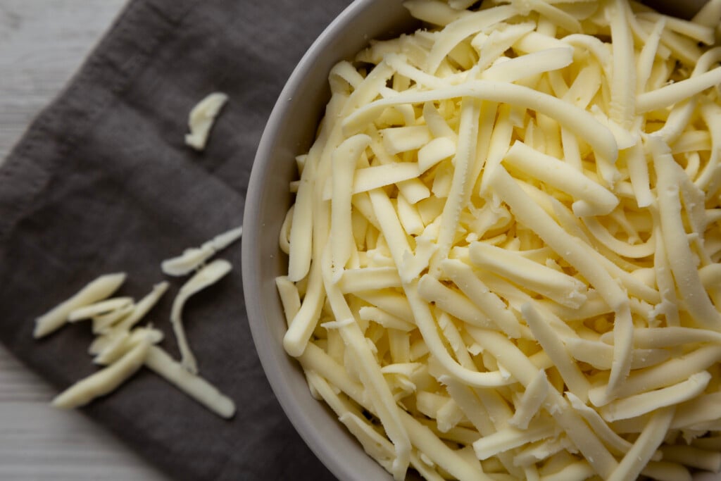 Shredded Mozzarella Cheese In A Bowl, Top View.
