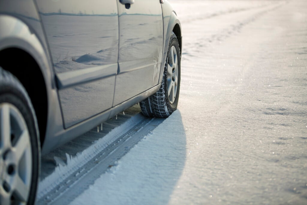 Close Up Of A Car Tire Parked On Snowy Road On Winter Day. Trans