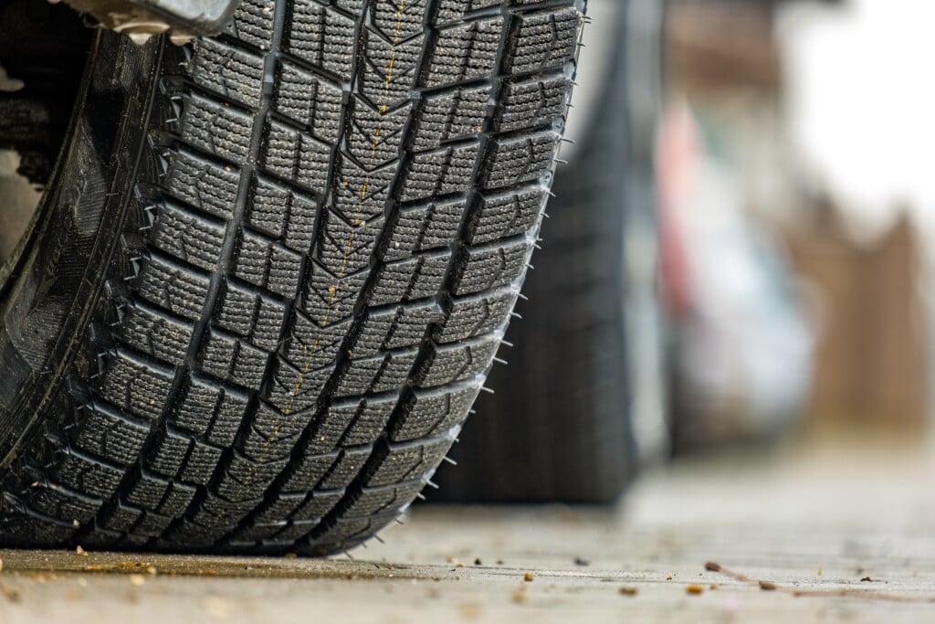 Closeup Of Parked Car On A City Street Side With New Winter Rubb