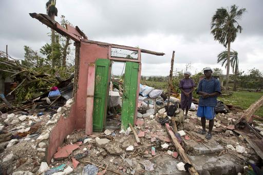 Saintanor Dutervil stands with his wife in the ruins of their home destroyed by Hurricane Matthew in Les Cayes