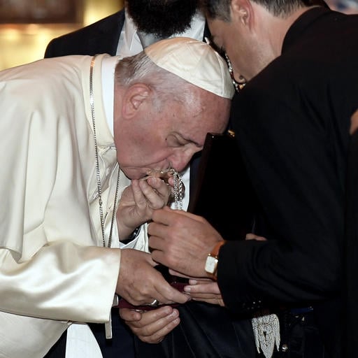 Pope Francis kisses a crucifix during a visit to the Svetitskhoveli Cathedral in Mtskheta