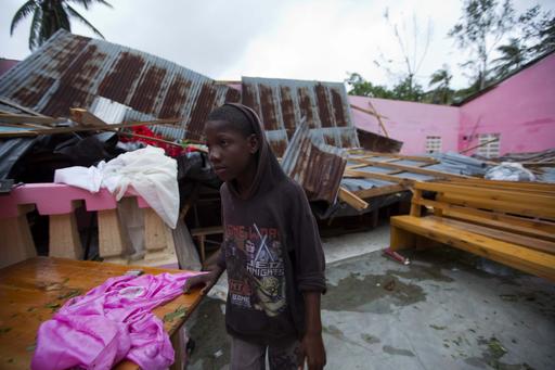 A boy stands inside a church after it was damaged by Hurricane Matthew in Saint-Louis