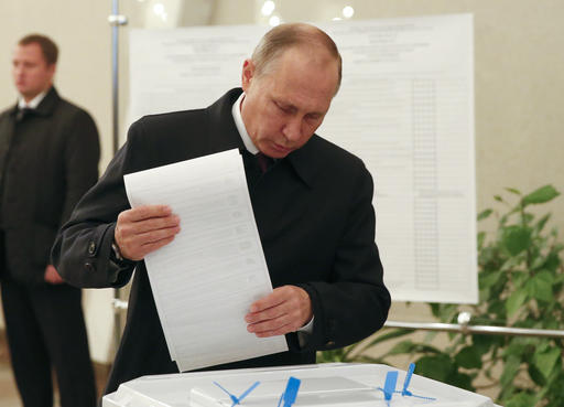 Russian President Vladimir Putin casts his ballot at a polling station during a parliamentary election in Moscow