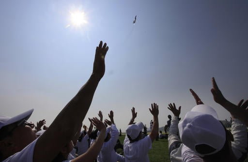 North Koreans wave as a fighter jet takes flight during an aerial display on Saturday