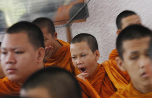 A novice Buddhist monk yawns before the start of ceremonies at Thammasat University in Bangkok