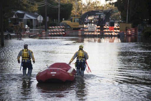 A swift water rescue team down a street covered by floodwaters caused by rain from Hurricane Matthew in Lumberton