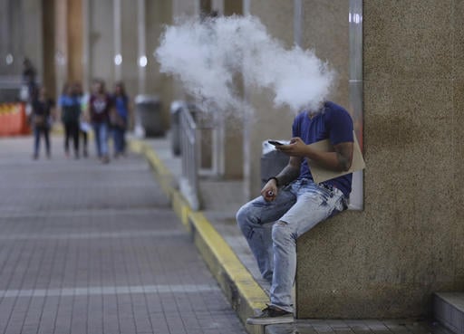 A Filipino uses an electronic cigarette outside a mall in Manila