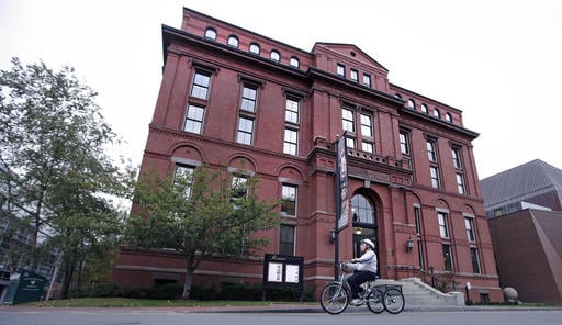A cyclist rolls past the Peabody Museum of Archaeology & Ethnology at Harvard University in Cambridge